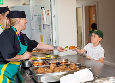 Twelve 15 staff serving a meal to a child